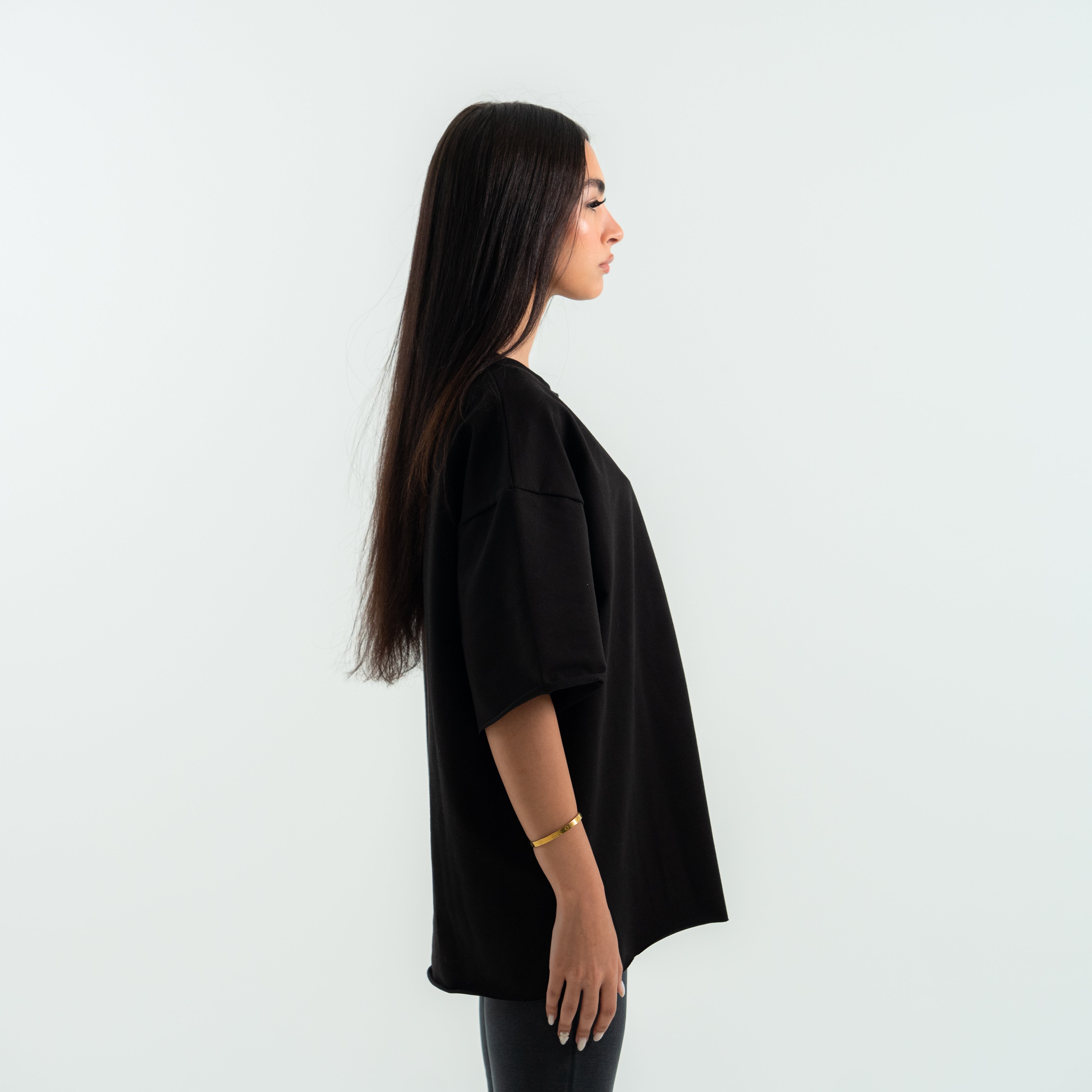 Woman wearing a black oversized shirt against a white background