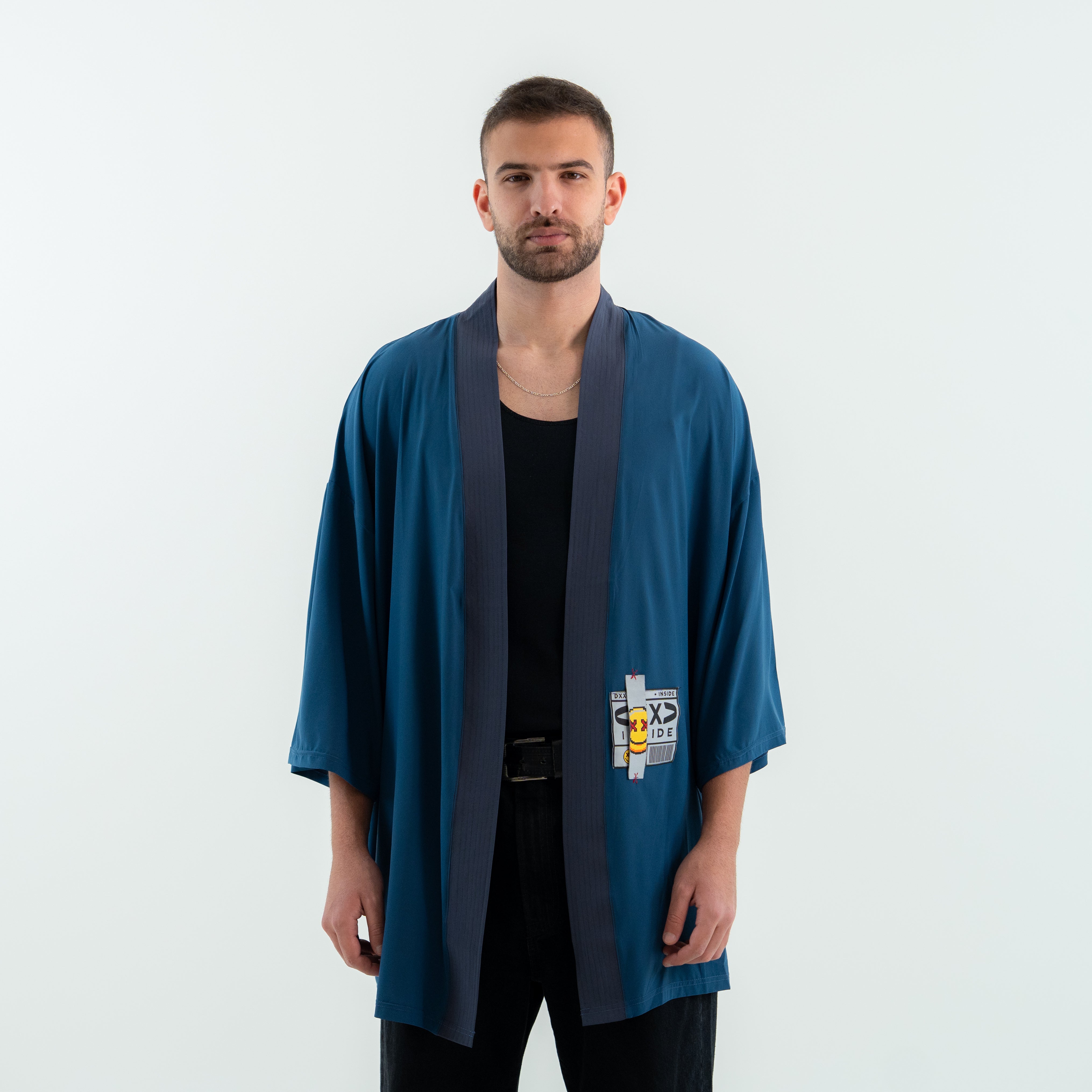 Man wearing a blue kimono-style garment with a logo on a white background