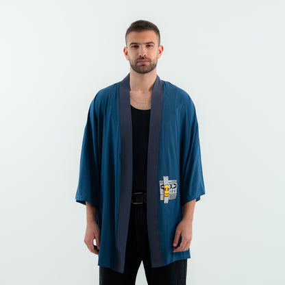 Man wearing a blue kimono-style garment with a logo on a white background