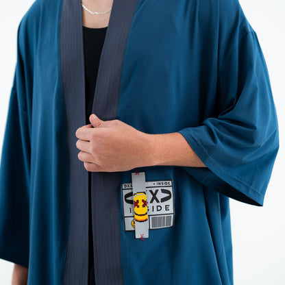 Person wearing a blue robe with a small yellow character sticker on a white background