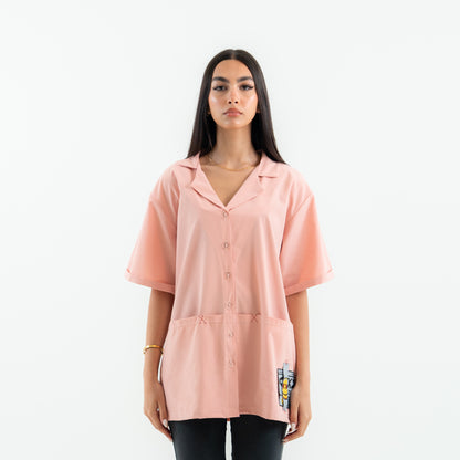 Woman wearing a pink oversized shirt on a white background