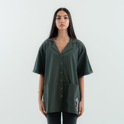 Woman wearing a green oversized shirt with button details on a white background