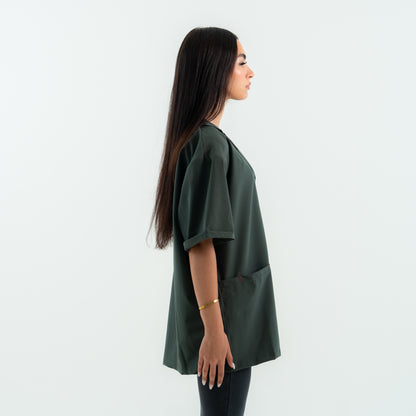 Woman wearing a green oversized shirt against a white background