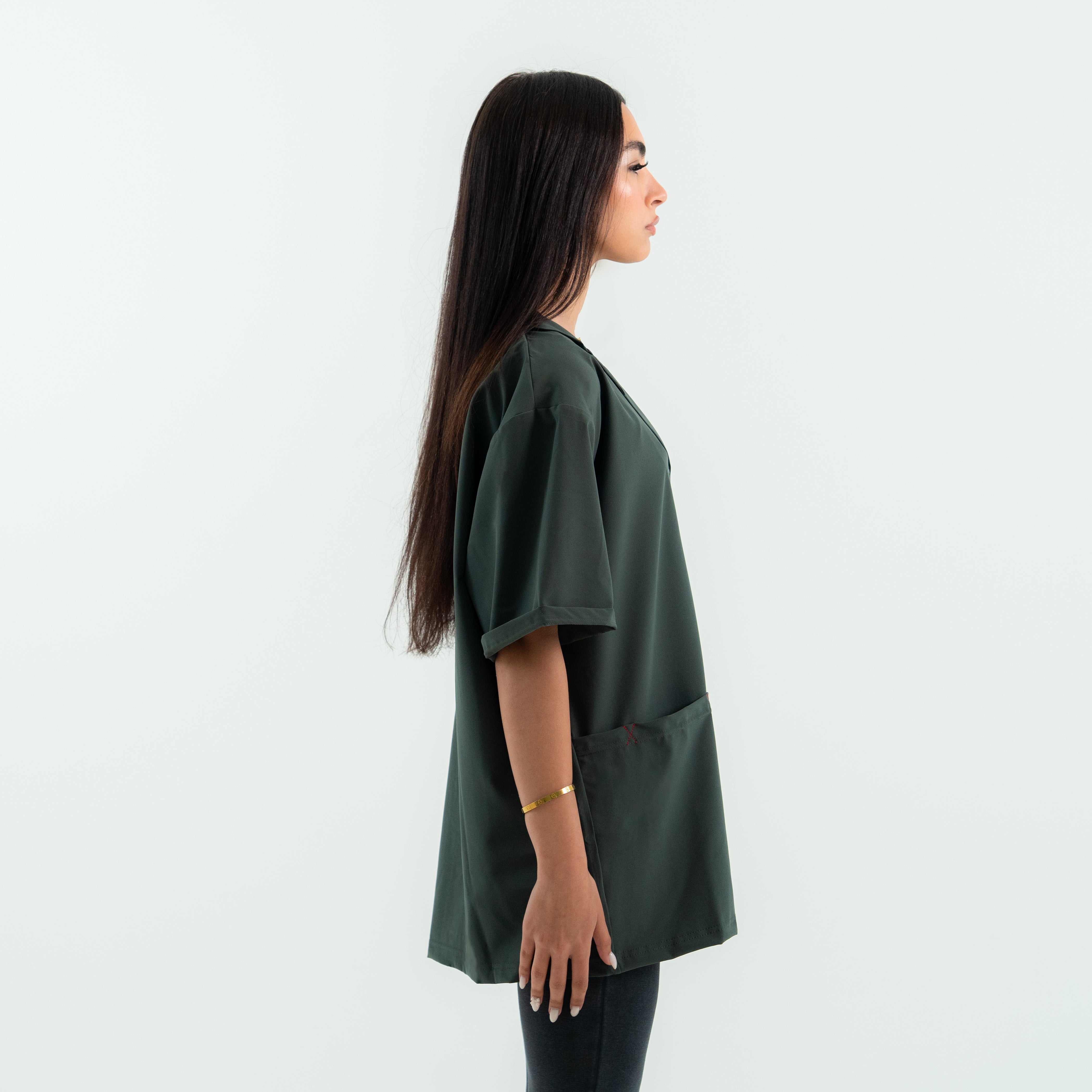 Woman wearing a green oversized shirt against a white background