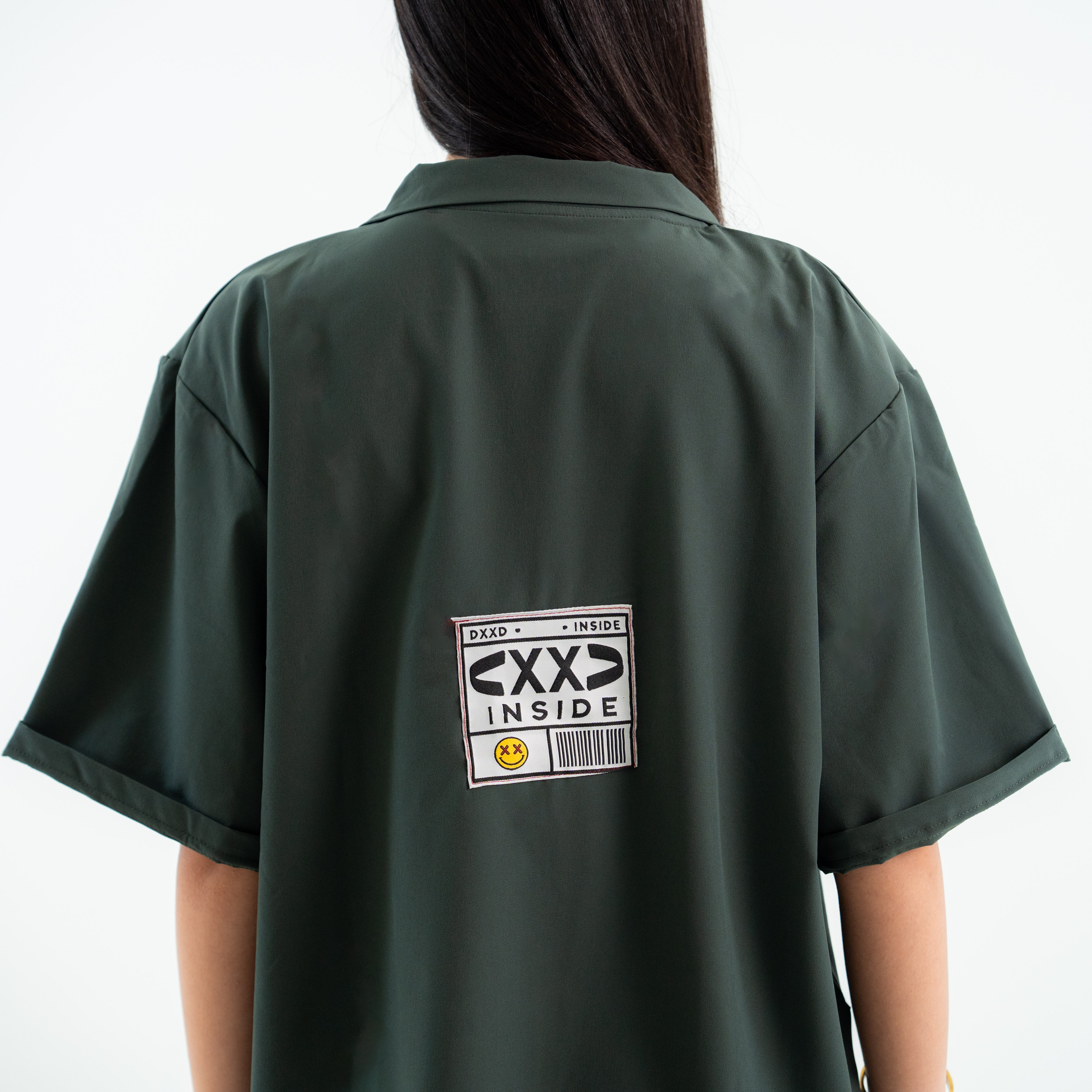 Green shirt with a label on the back against a white background
