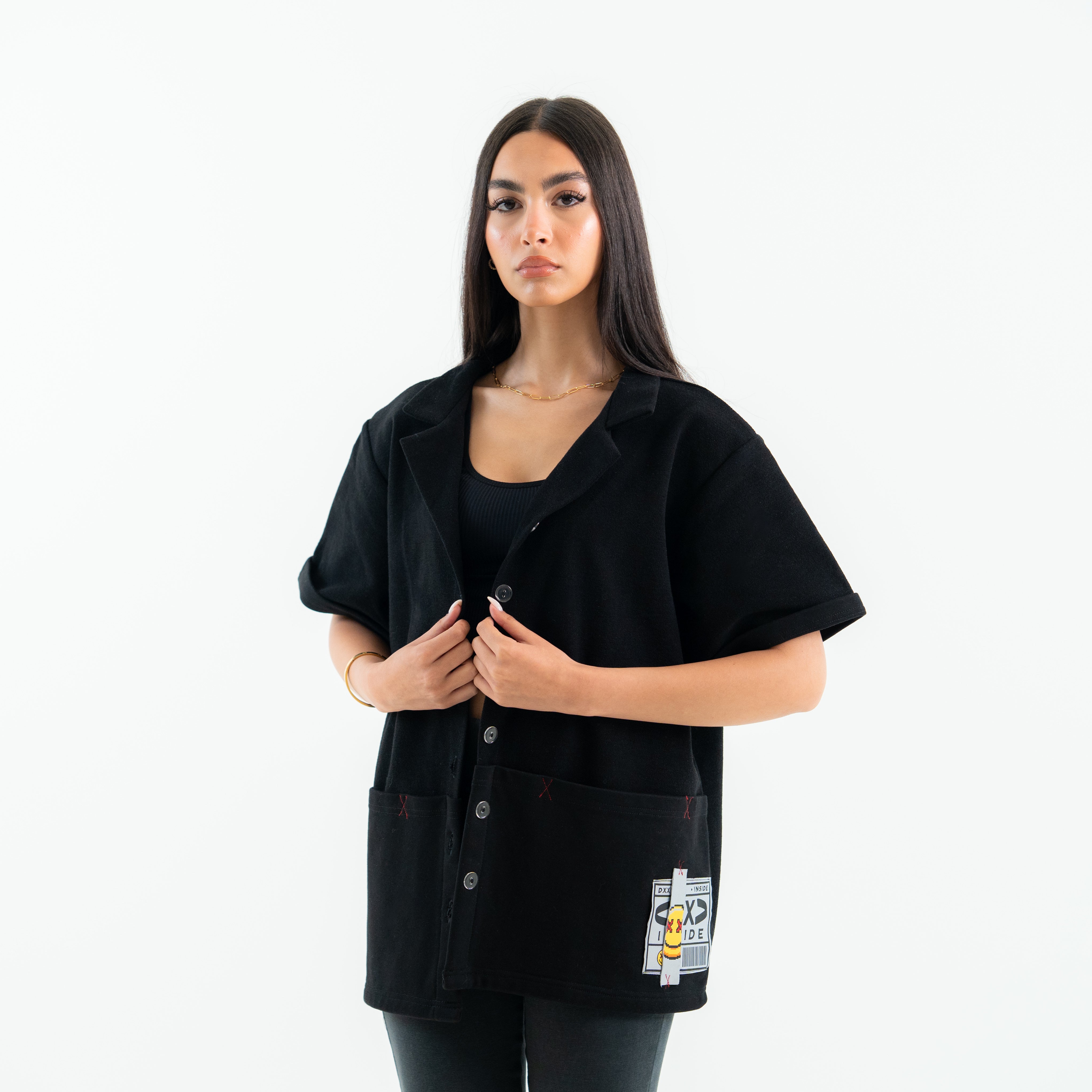 Person wearing a black outfit with a patch on a white background