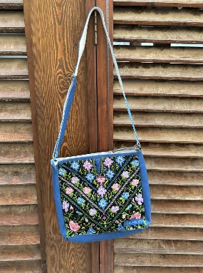 Handbag with floral pattern hanging on a wooden door