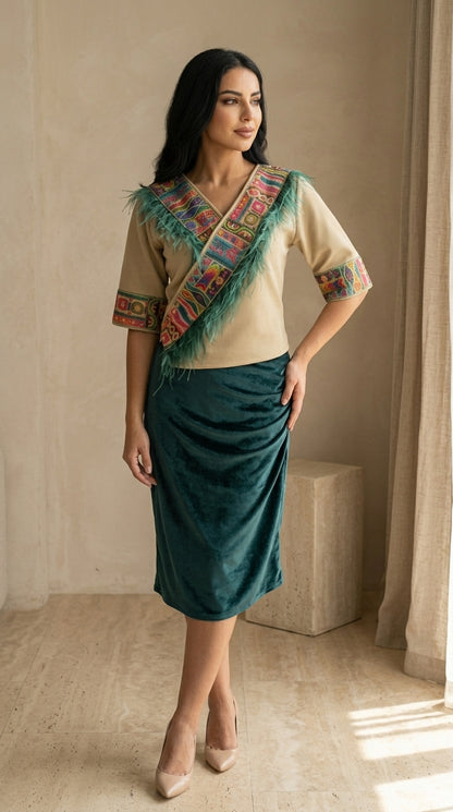 Woman wearing a traditional outfit with a green skirt and beige top, standing indoors.