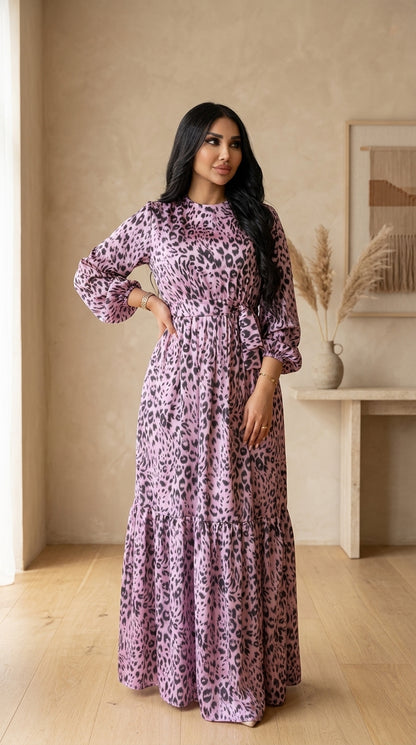 Woman wearing a long, patterned dress in a room with a neutral color palette.