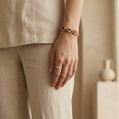 Person wearing a bracelet and ring with a neutral background
