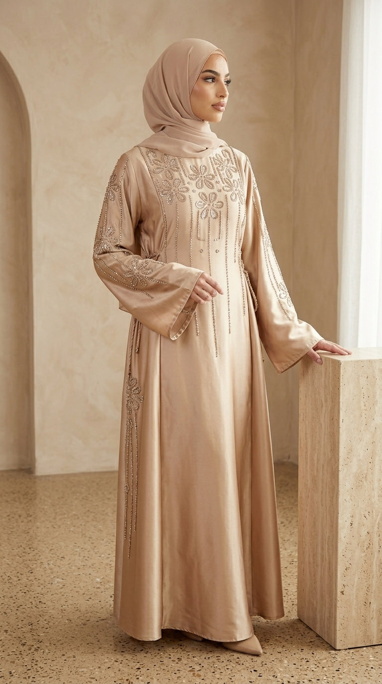 Woman wearing a beige embroidered abaya in an elegant interior setting