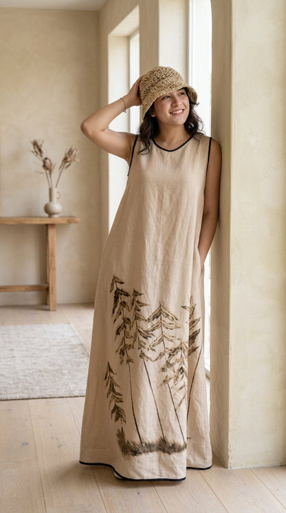 Woman wearing a beige dress with nature print standing in a bright room.
