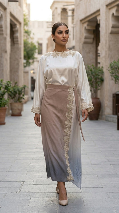 Woman wearing a white blouse with lace details and a beige skirt in an outdoor setting.
