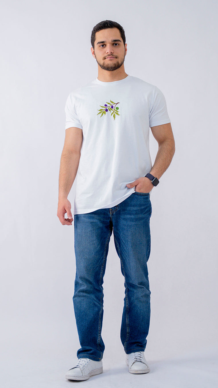 Man wearing a white t-shirt with a floral design and blue jeans on a white background