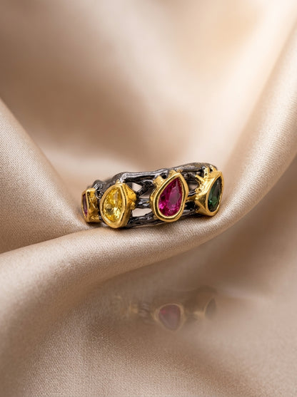 Ring with multicolored gemstones on a beige fabric background