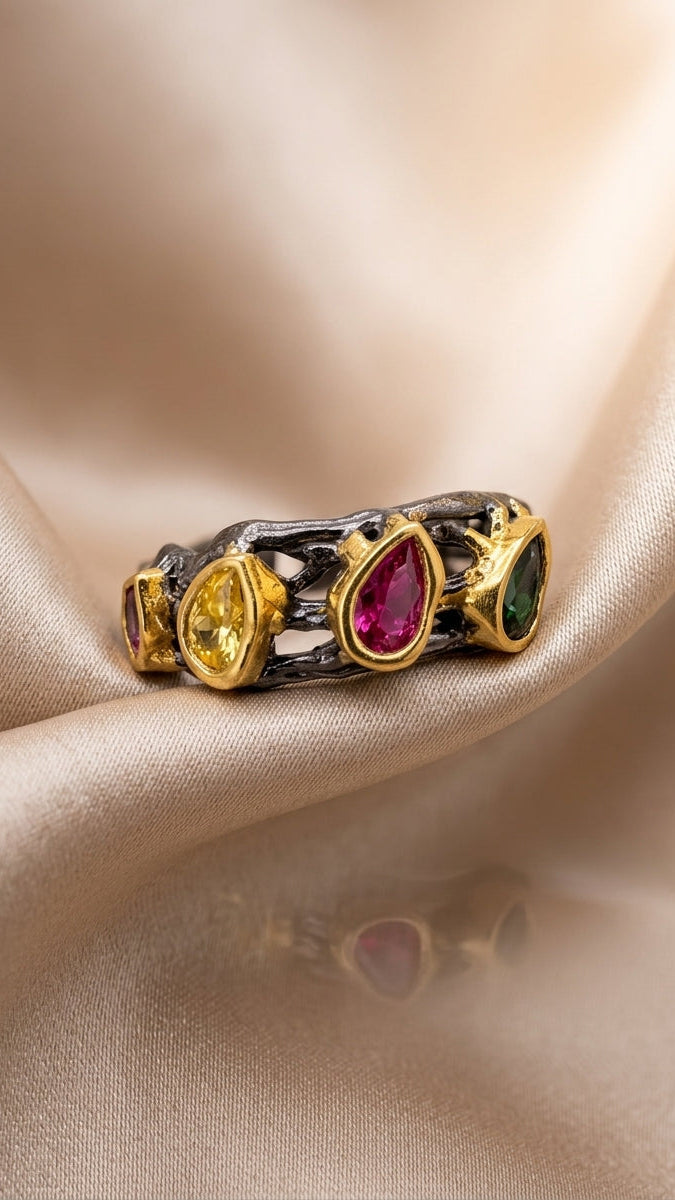 Ring with multicolored gemstones on a beige fabric background