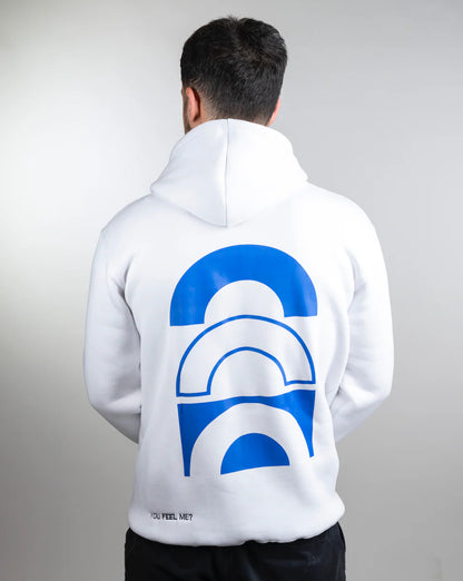 Person wearing a white hoodie with a blue and white graphic on the back against a gray background