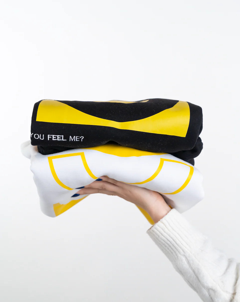Person holding a black and yellow pillow with text on a white background