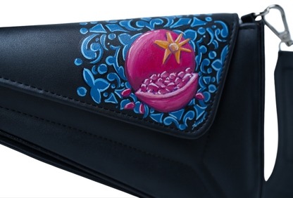 Black handbag with pink pomegranate design and blue floral patterns on a white background
