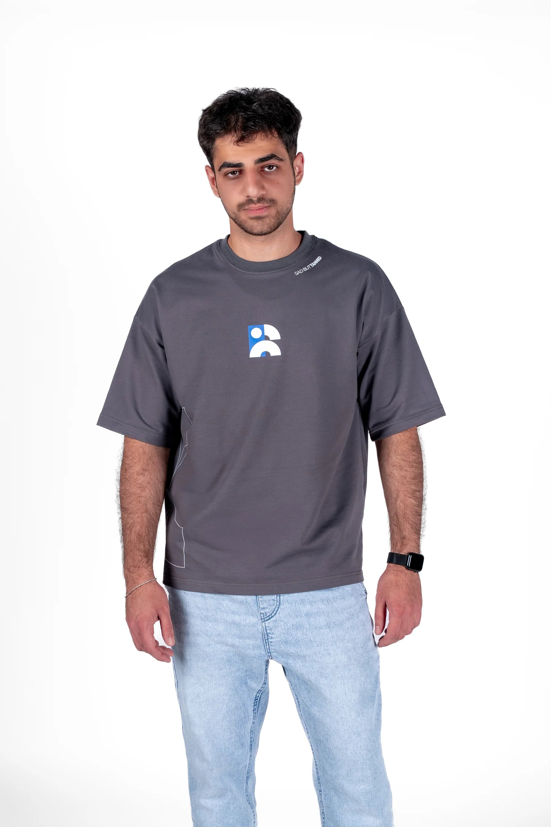 Man wearing a gray t-shirt with a logo on a white background