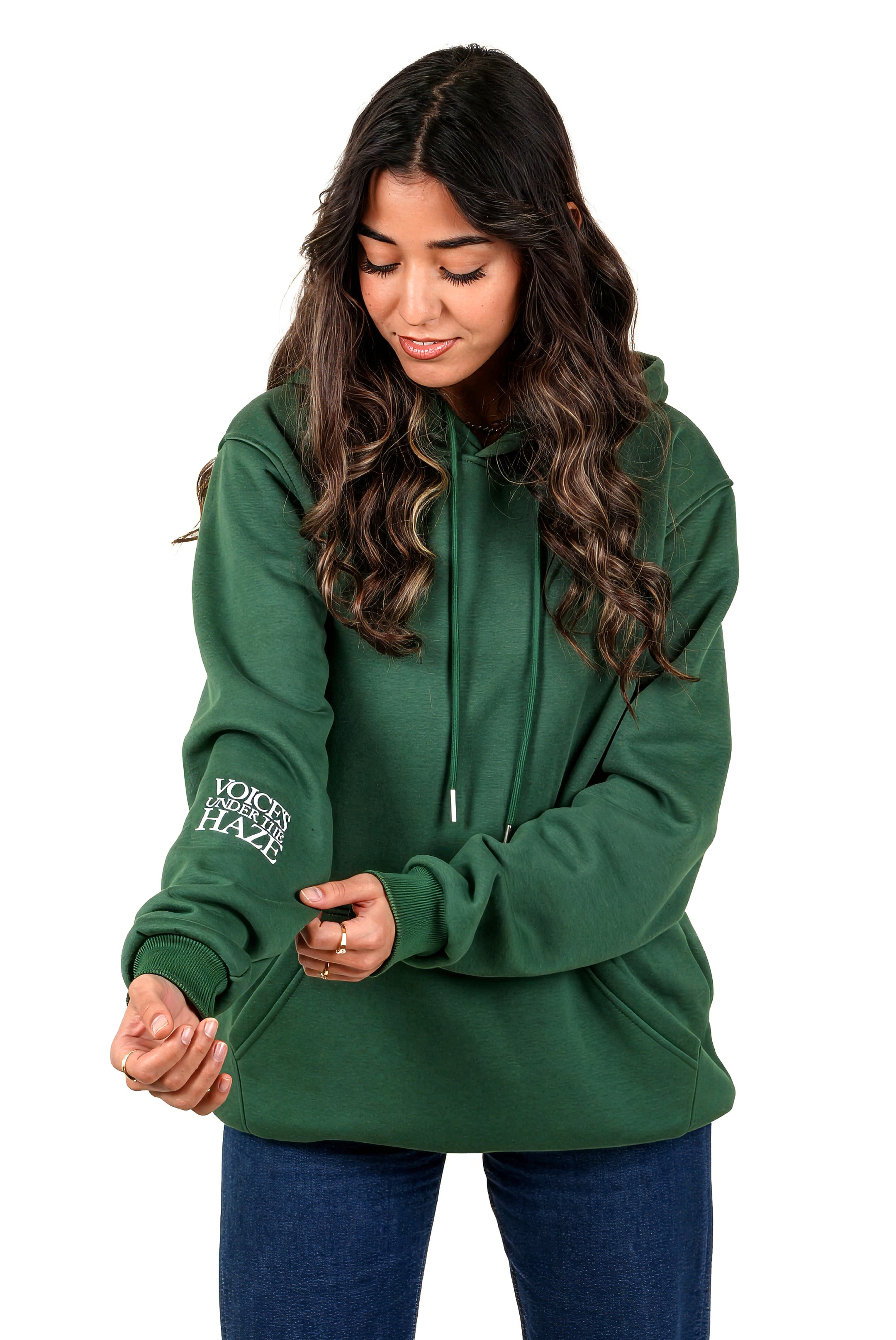 Woman wearing a green hoodie with text on the sleeve against a white background