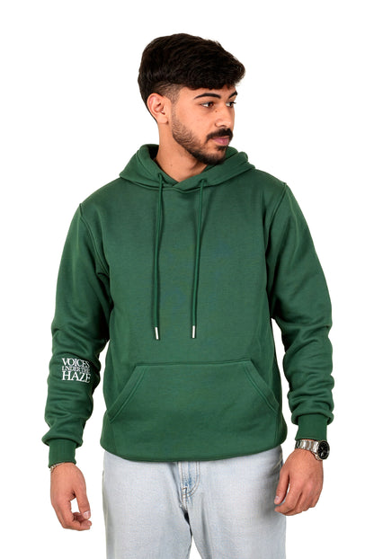 Man wearing a green hoodie with text on sleeves against a white background