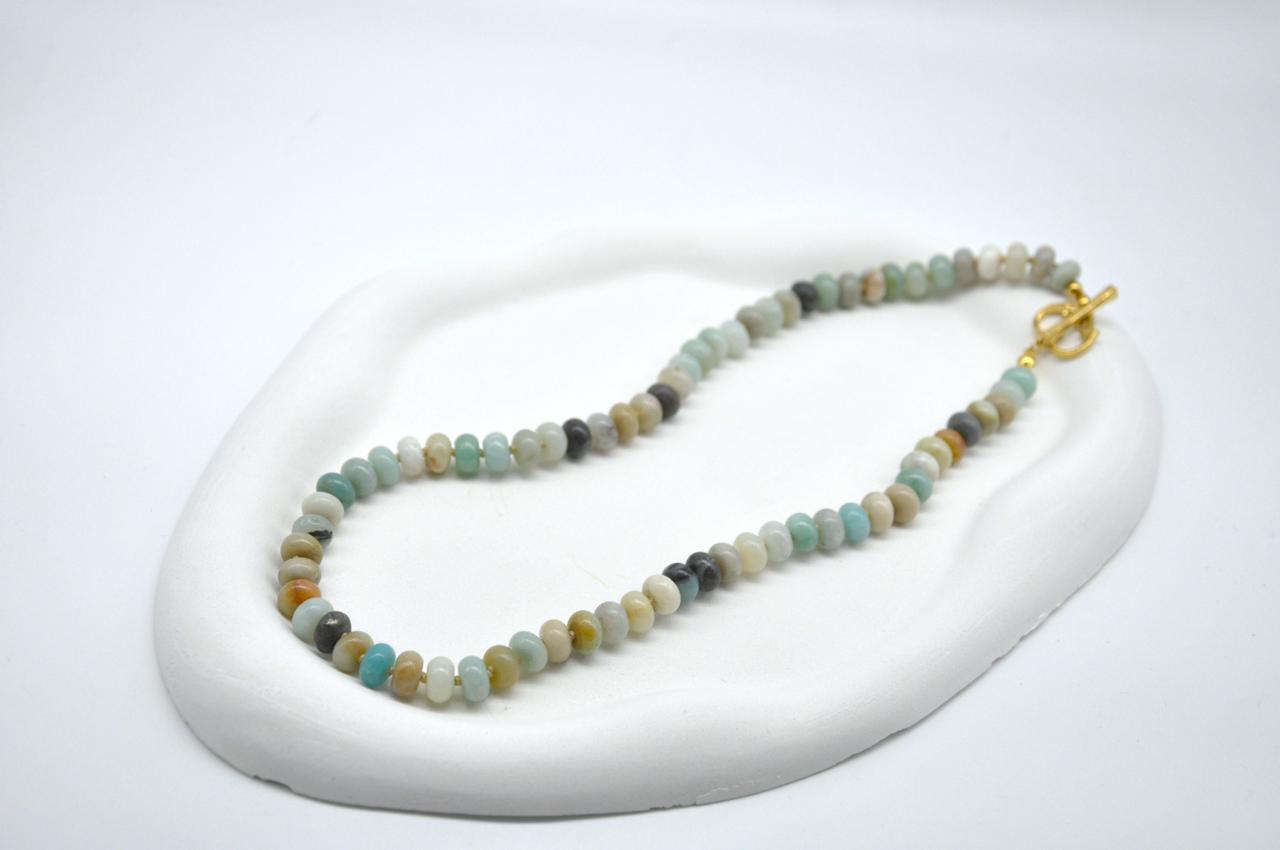Beaded necklace on a white stand with a white background