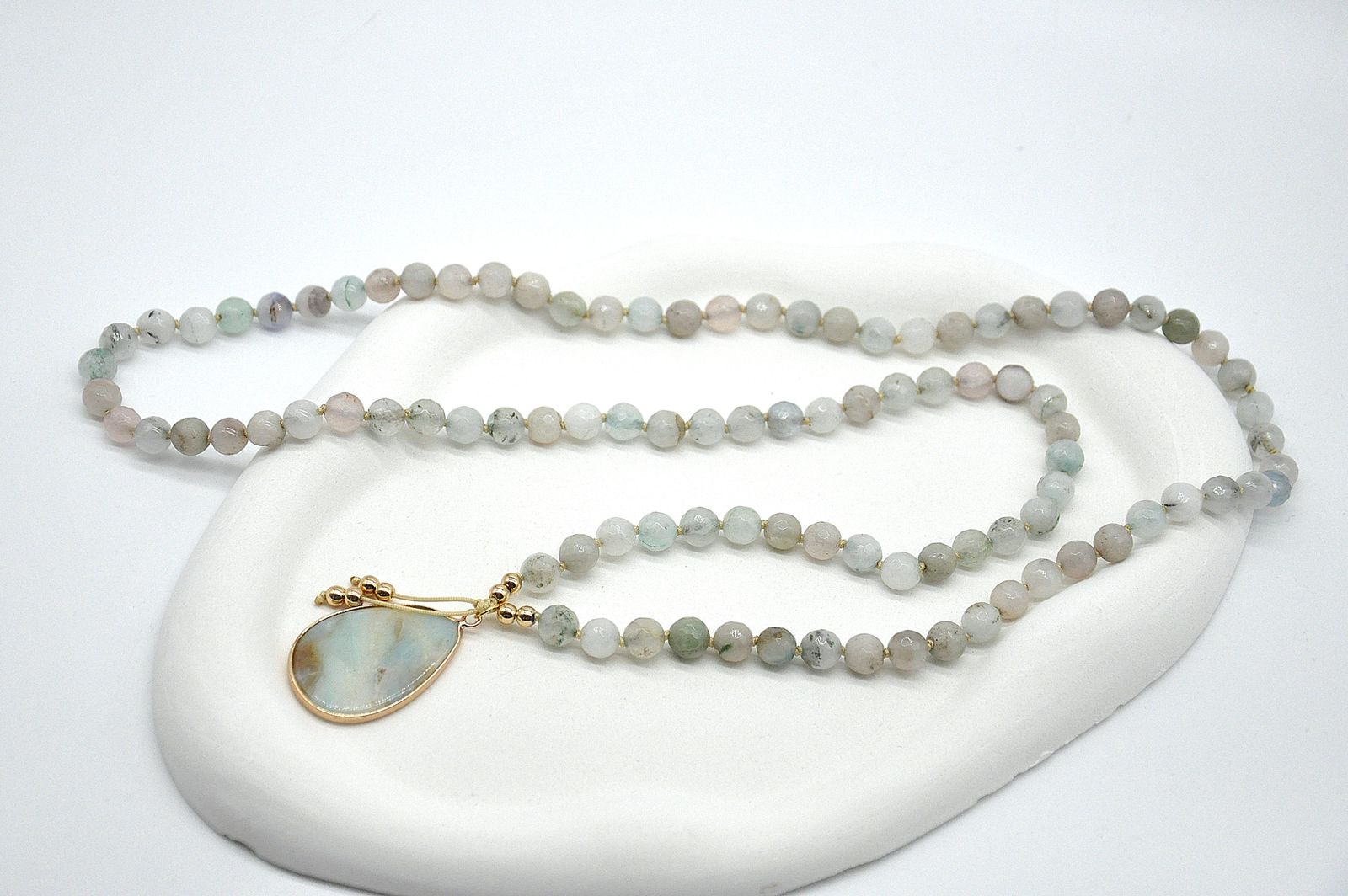 Beaded necklace with a gold pendant on a white background
