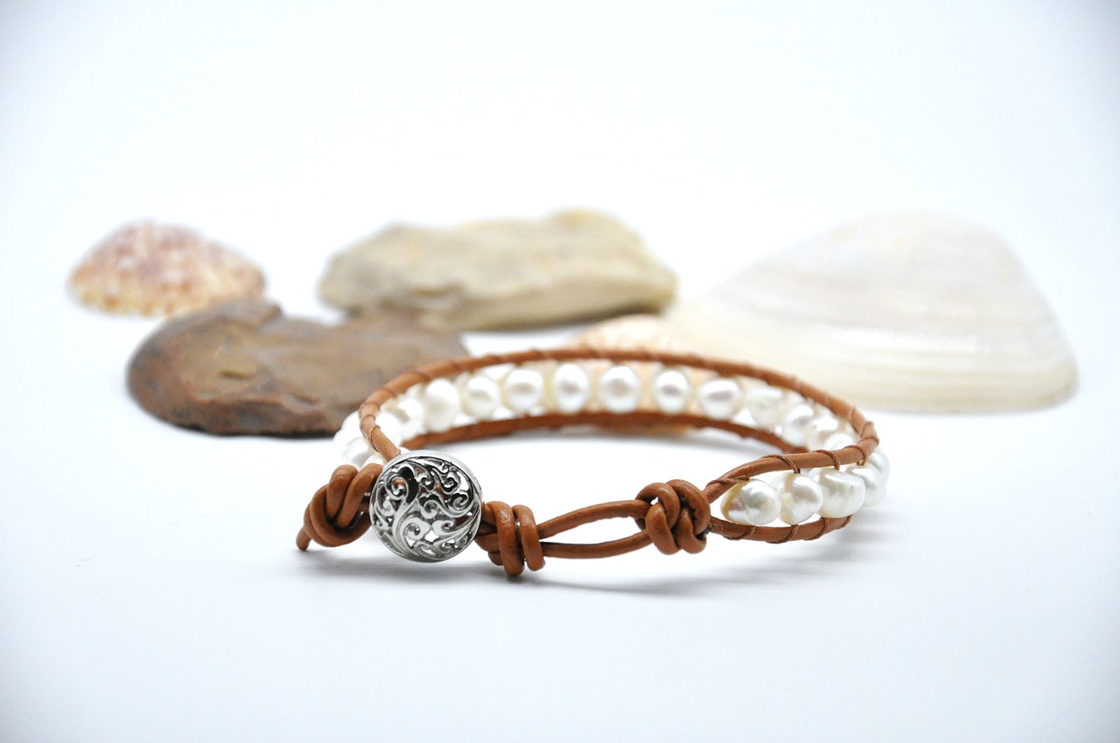 Bracelet with pearls and a decorative clasp on a white background