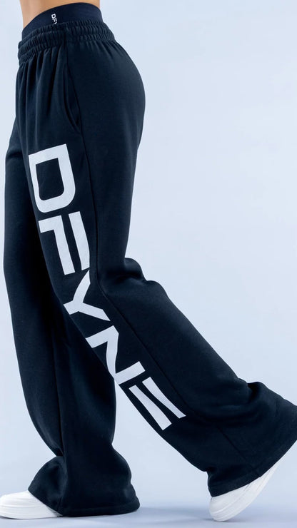 Black sweatpants with 'DEYN' branding on a light blue background