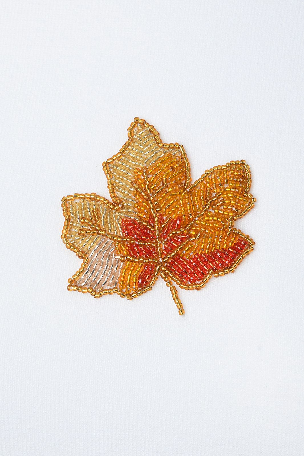 Embroidered leaf patch with autumn colors on a white background