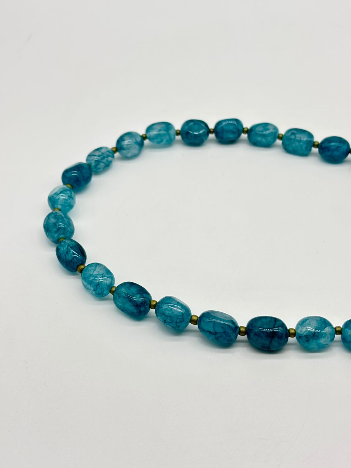 Blue beaded necklace on a white background