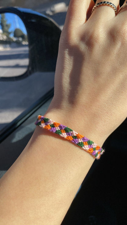 Colorful braided bracelet on a wrist with a blurred background