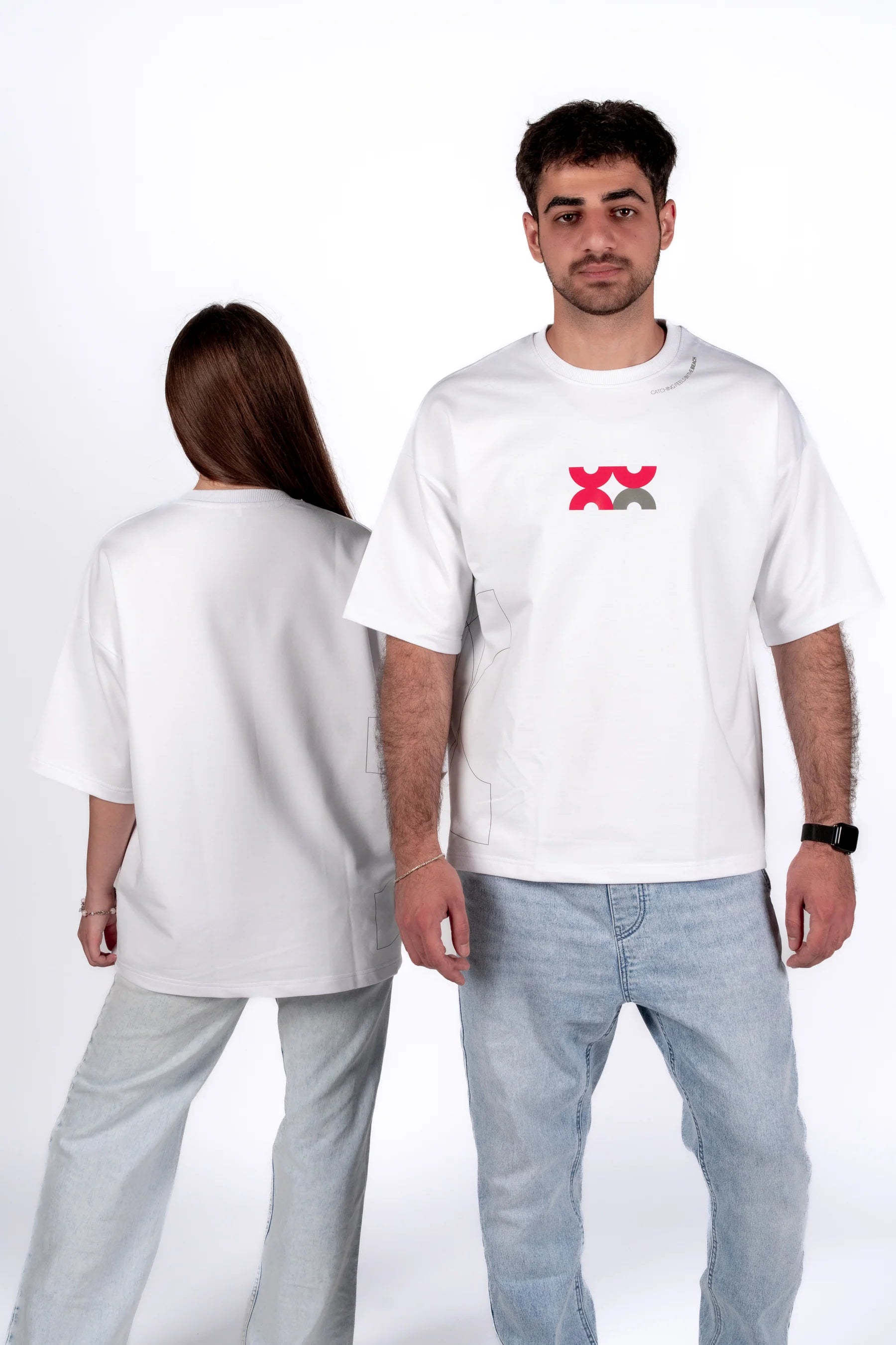 Two people wearing white t-shirts with a logo on a plain background