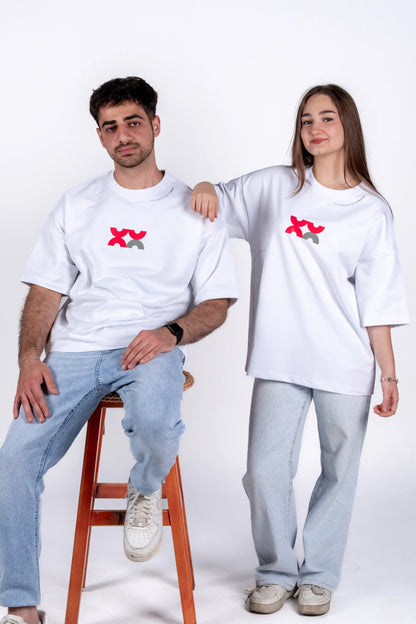 Two people wearing matching white t-shirts with red and black designs on a white background