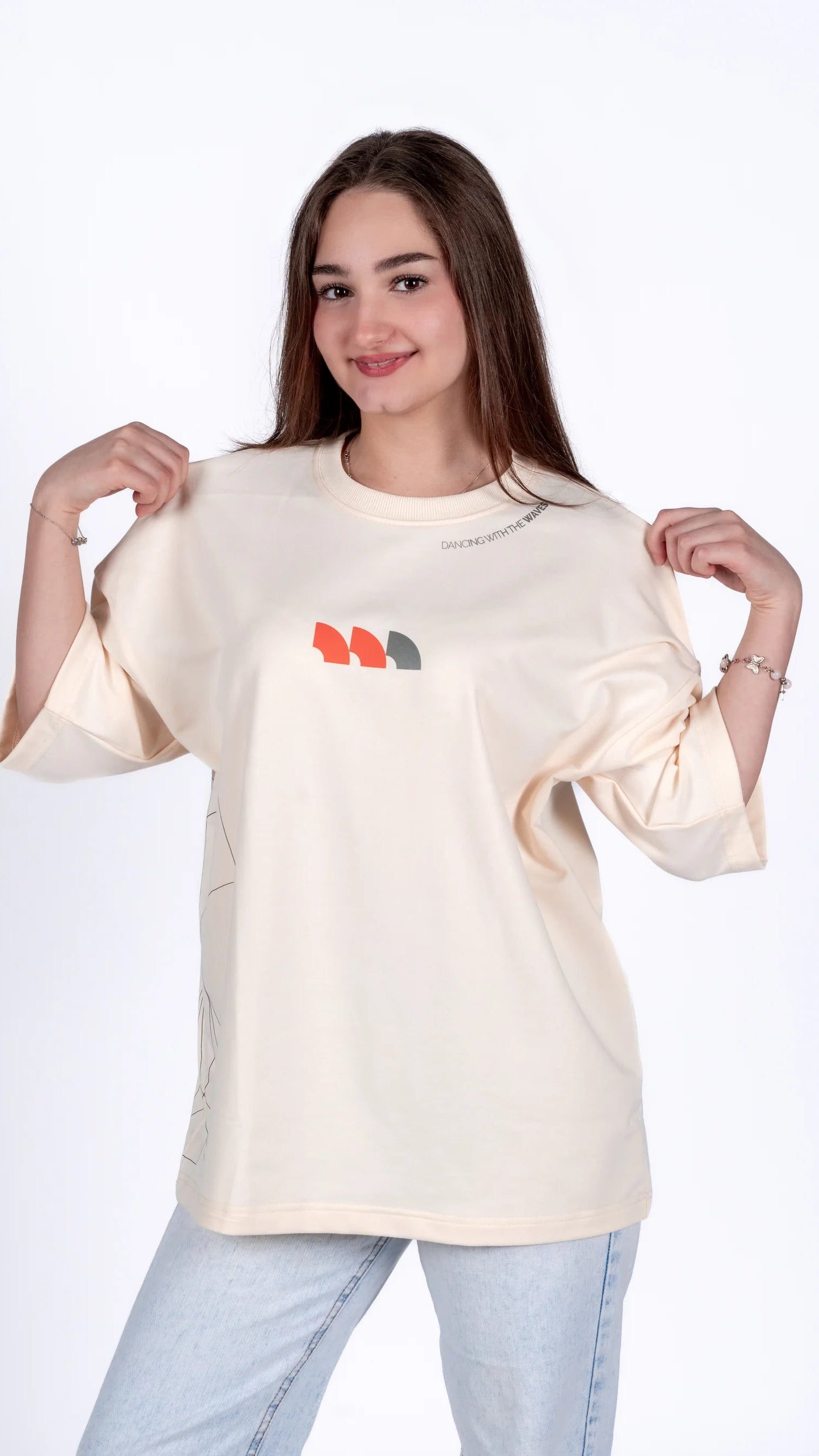 Woman wearing a cream-colored t-shirt with colorful text design on a white background