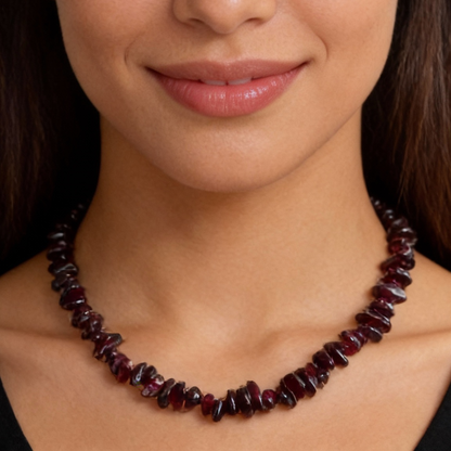 Woman wearing a red beaded necklace against a white background