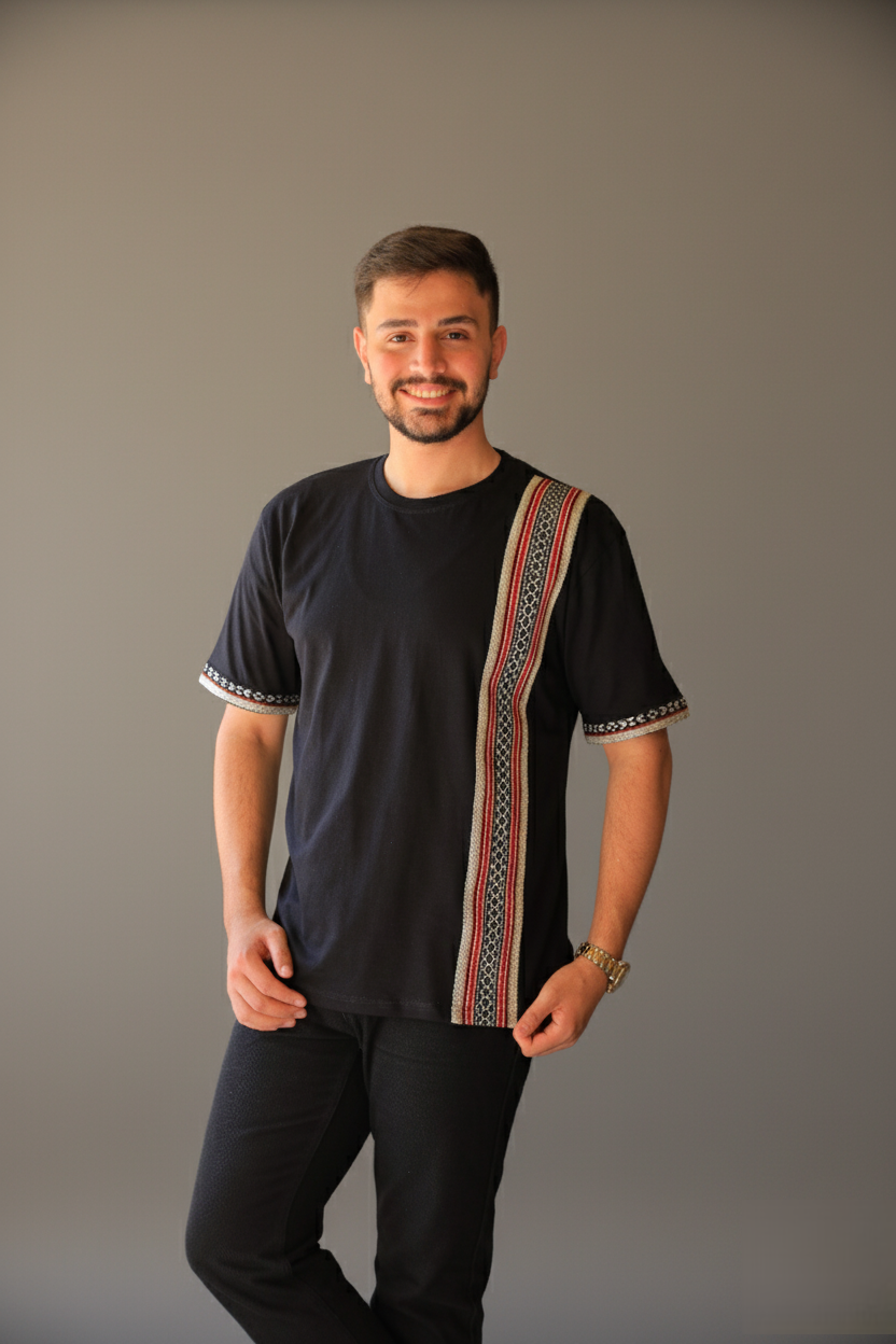 Man wearing a black shirt with a colorful patterned design on a gray background