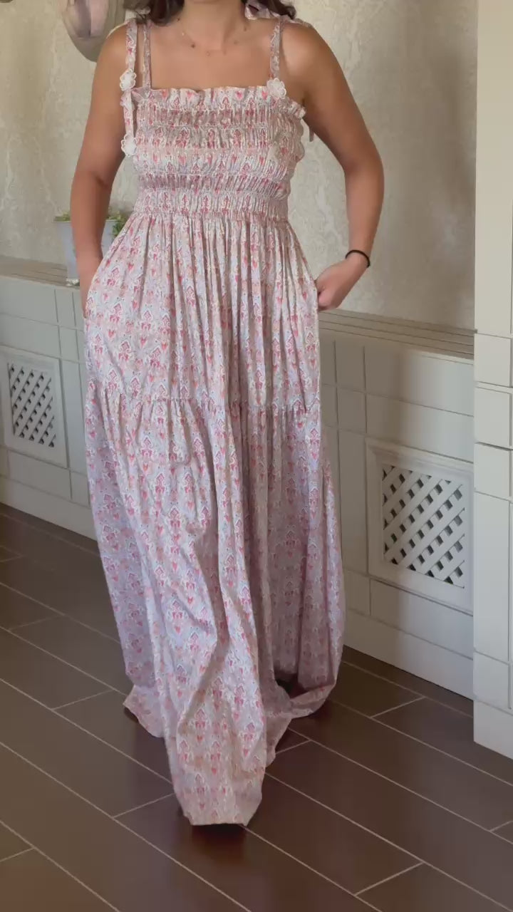 Woman wearing a floral dress against a plain background