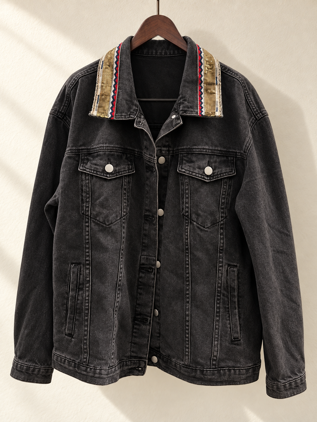 Black Denim Jacket with Beaded Embroidered Back Panel — front view on wooden hanger